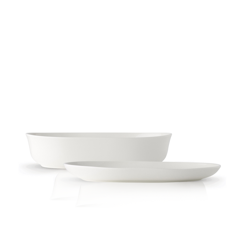 The Adam Liaw Everyday Noritake oval serving set, including a 24cm white porcelain bowl and a 26cm white porcelain platter, shown together against a white background.
