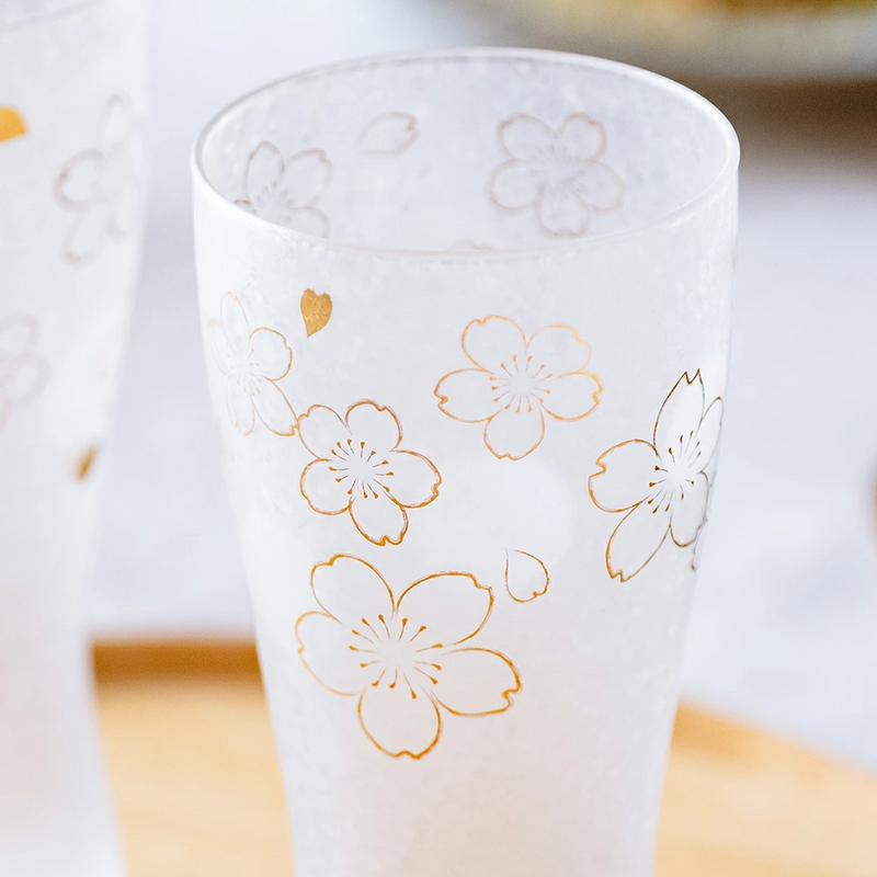 Close-up of the frosted glass showcasing intricate gold sakura blossoms and heart motifs.

