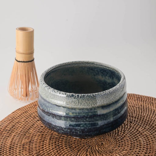 Ao Unofu Japanese Matcha Bowl with a milky blue and white glaze, shown with a bamboo tea whisk resting inside.