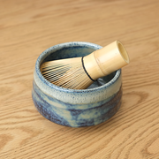 Ao Unofu Japanese Matcha Bowl with a milky blue and white glaze, shown with a bamboo tea whisk resting inside.