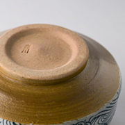 The unglazed foot (kōdai) of the Arahami matcha bowl, with a small maker's mark stamped into the clay.