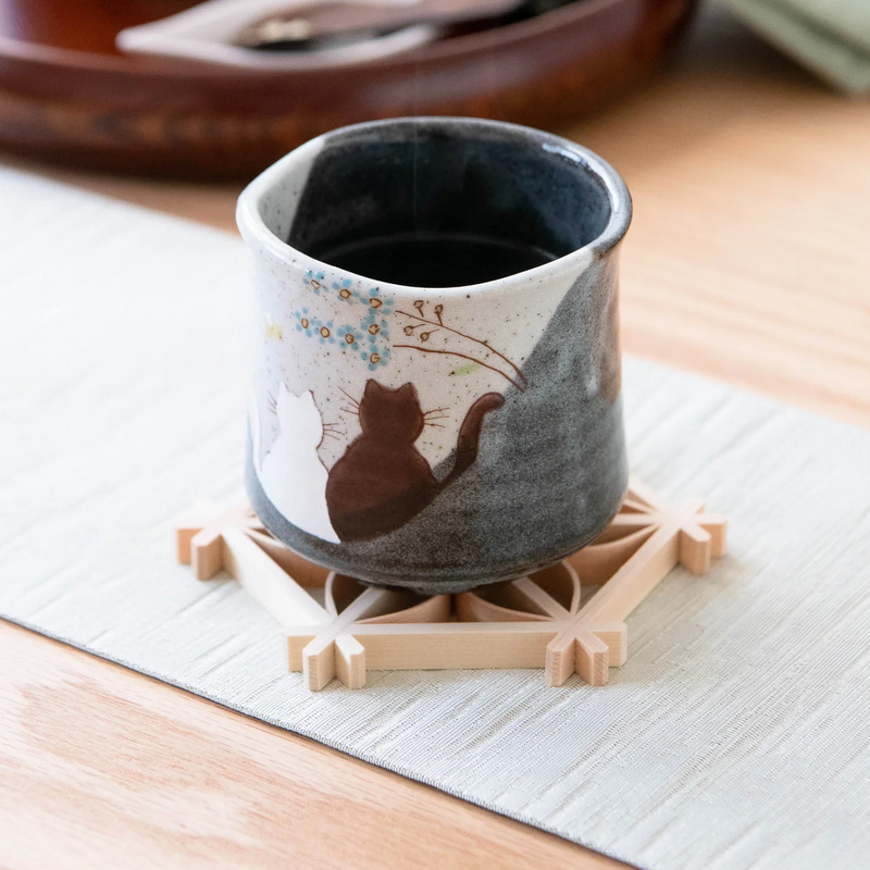 The Atelier Yu Cats In Sunny Spot Kutani handmade mug, showing an illustration of two cats against a speckled grey background with blue and gold dots.