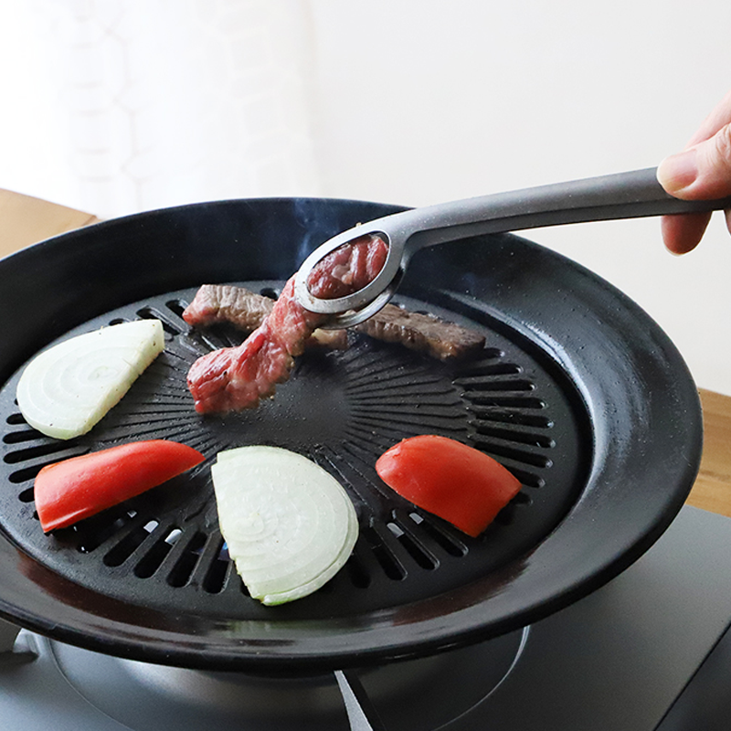 Stainless steel tongs designed for draining oil efficiently.