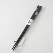 Close-up of the top section of black chopsticks featuring a blue and white circular pattern.

