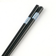 Pair of black chopsticks with blue circle design inside clear packaging labeled Brush Blue.







