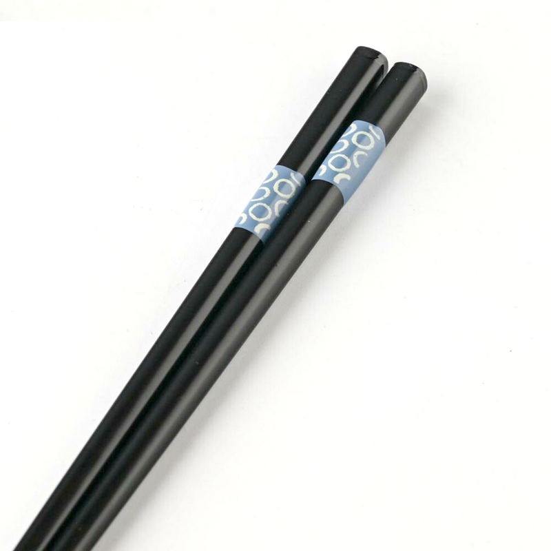 Pair of black chopsticks with blue circle design inside clear packaging labeled Brush Blue.








