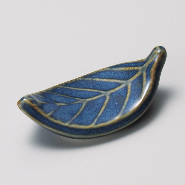 Elegant porcelain chopstick rest shaped like a leaf, adorned with deep blue patterns. Made in Japan.