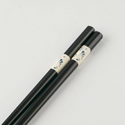 A close-up view of the textured, non-slip tips of the black Japanese chopsticks.