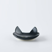 Side view of a black Japanese cat cutlery rest highlighting the curved base and glossy surface
