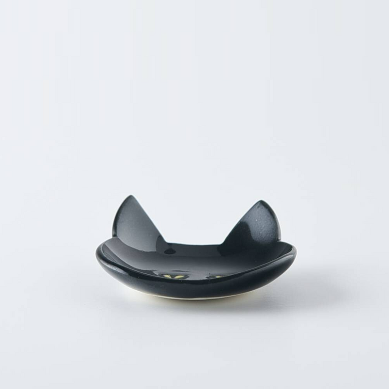 Side view of a black Japanese cat cutlery rest highlighting the curved base and glossy surface
