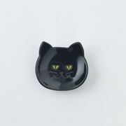 Black Japanese cat cutlery rest on a plain background showcasing glossy finish and yellow eyes
