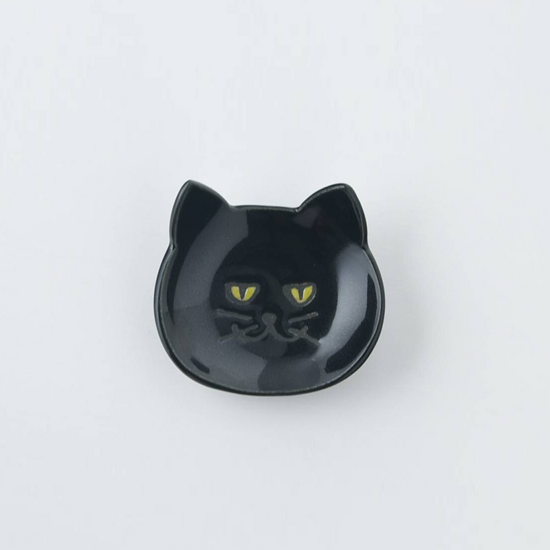 Black Japanese cat cutlery rest on a plain background showcasing glossy finish and yellow eyes
