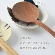 Close-up of a Japanese cat cutlery rest with a wooden spoon, illustrating its use as a condiment dish

