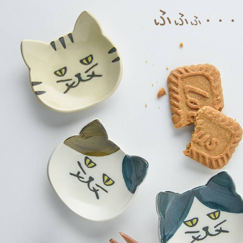 Array of Japanese cat cutlery rests in various colours used to hold biscuits, demonstrating their functionality as snack plates





