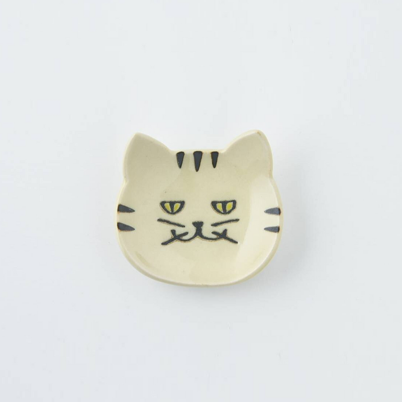 Cream-coloured Japanese cat cutlery rest with subtle facial details on a plain background
