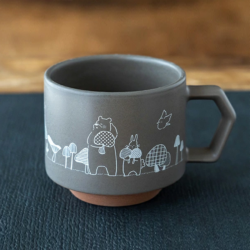 A grey CHIPS stackable mug featuring a whimsical white line drawing of a bear and rabbit holding mushrooms, part of the Mori no Kinoko Club collection.