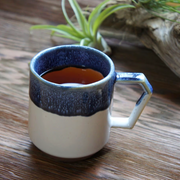 The CHIPS Stack Mug in the White Navy Drop colour, showing its unique angular handle and textured blue glaze over a white and terracotta base.