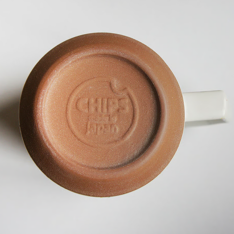A close-up of the unglazed clay base of the CHIPS mug, showing the 'CHIPS made in japan' maker's mark stamped into the clay.