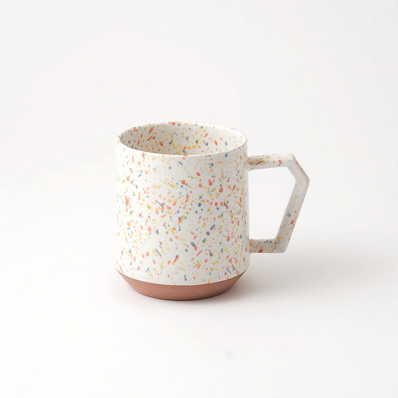 The CHIPS Stack Mug in the Splash White Orange colour, showing its colourful terrazzo-style splatter and unique angular handle.