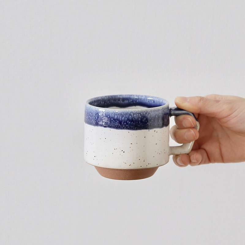  hand holding the 280ml CHIPS Stack Mug to demonstrate its size and the comfortable grip of the angular handle.