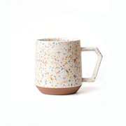 The CHIPS Stack Mug in the Splash White Orange colour, showing its colourful terrazzo-style splatter and unique angular handle.