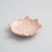 An angled product image of the pink Fiore Dahlia mini plate, showing its delicate flower shape and crackled glaze.

