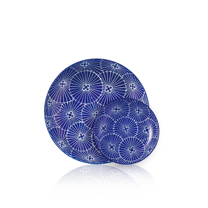 Elegant deep blue ceramic plate adorned with intricate white Japanese umbrella patterns, embodying traditional craftsmanship.