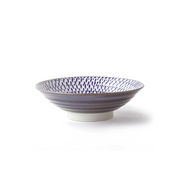 A side view of the Dander and Chiriuzu Japanese Ramen Bowl, showing its ribbed purplish-grey exterior, white footed base, and speckled purple interior.