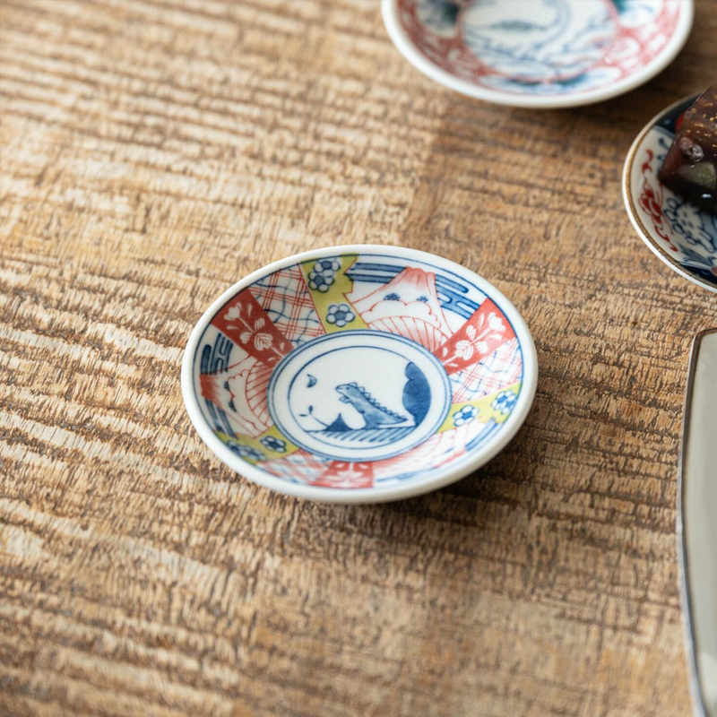 A small Edokko Dinosaur Asahiryu mini plate featuring a traditional Japanese geometric pattern in red, blue, and yellow with a dinosaur illustration in the centre.