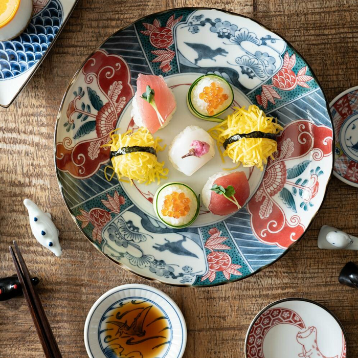 Tabletop view of sushi served alongside several Edokko mini plates with unique dragon and nature-themed designs.