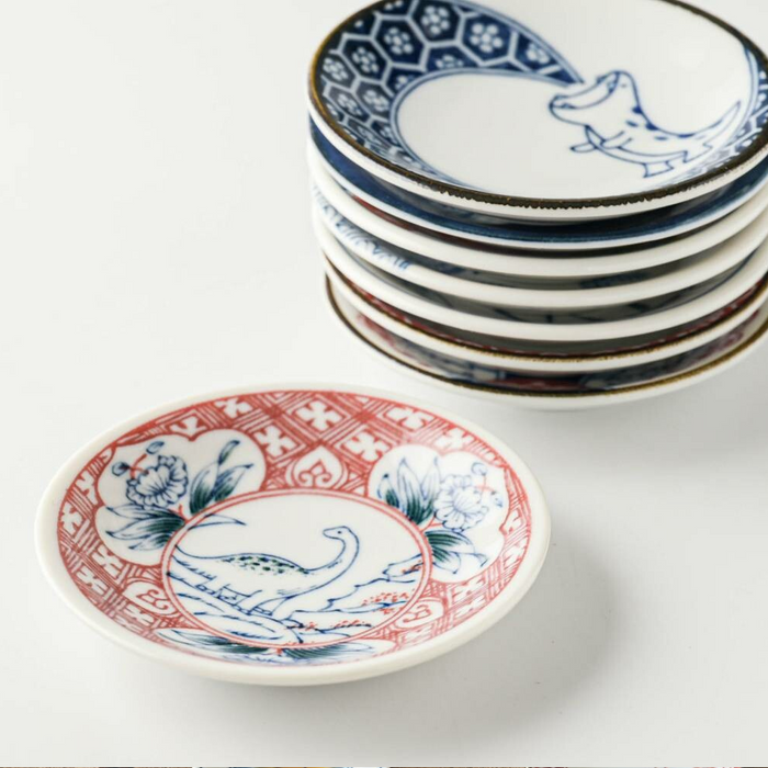 Close-up of Edokko Red and Blue Flame Dragon Mini Plates stacked with a red floral patterned plate in front.