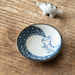 Edokko Blue Flame Dragon Mini Plate on a wooden surface with a small white ceramic dinosaur ornament.