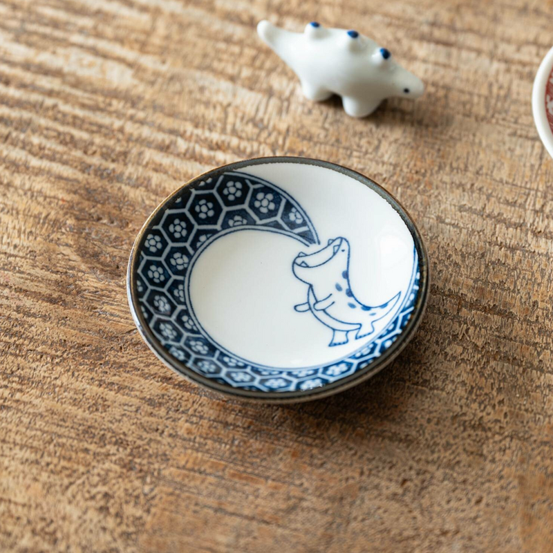 Edokko Blue Flame Dragon Mini Plate on a wooden surface with a small white ceramic dinosaur ornament.