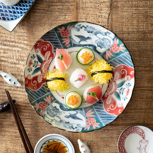 The Edokko Dinosaur dinner plate being used to serve a colourful assortment of temari sushi on a wooden table.

