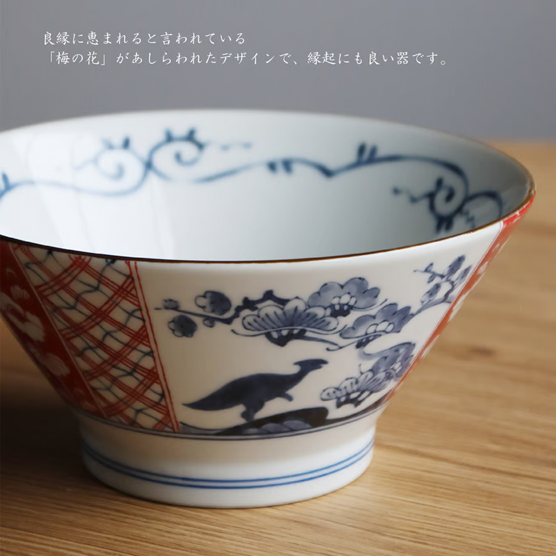 Edokko Dinosaur Donburi Bowl held in hand, featuring traditional plum blossom and bird patterns in blue and red.