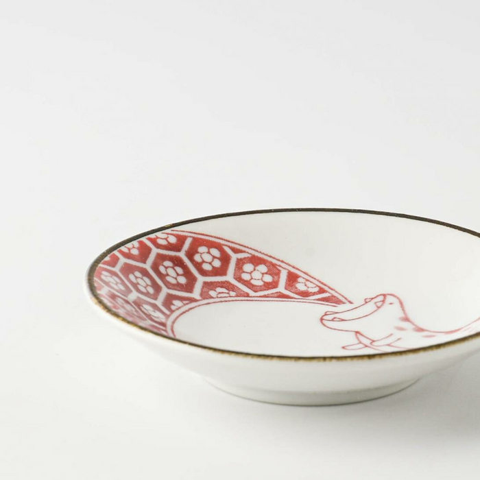 A side profile of the red-patterned Edokko mini plate with a dinosaur design, showing its slightly elevated shape and fine rim detailing.

