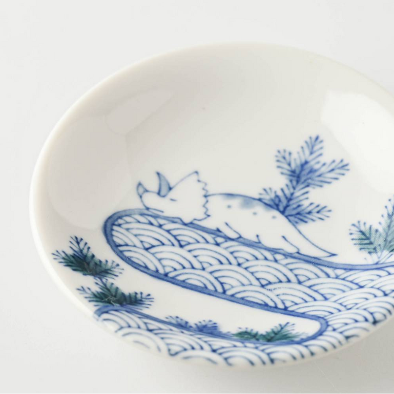 A detailed close-up of the playful triceratops illustration resting on the traditional Japanese seigaiha wave pattern.

