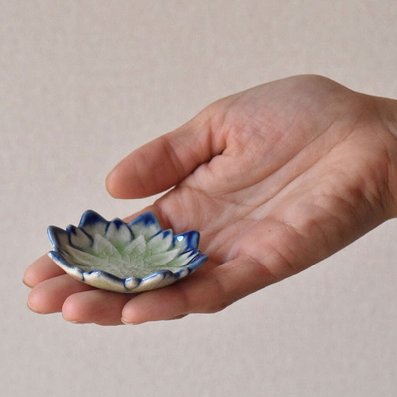 The small Fiore Dahlia mini plate in green held in the palm of a hand to show its petite size.

