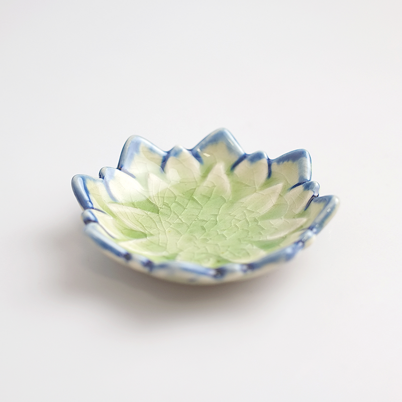 
An angled product image of the green Fiore Dahlia mini plate, showing its flower shape and light green and blue crackled glaze.

