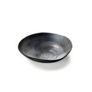 The Touga Forest Lake Serving Bowl, showing its organic, uneven shape and deep, dark speckled glaze on a white background.