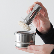 Freiz Stainless Steel Oil Basting Set with a removable brush, held by hand for demonstration.
