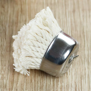 A close-up of the Freiz replacement basting brush head, made of white brocade fabric and stainless steel, resting on a wooden surface.






