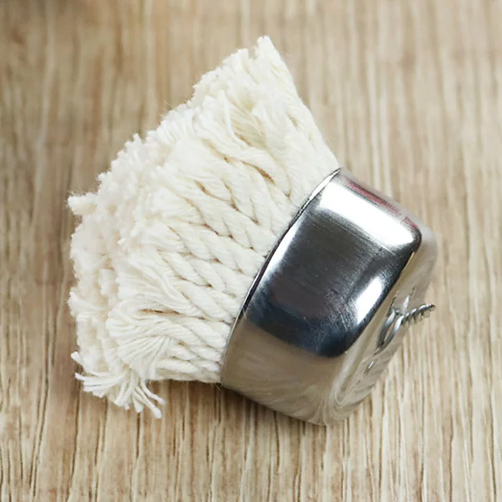 A close-up of the Freiz replacement basting brush head, made of white brocade fabric and stainless steel, resting on a wooden surface.






