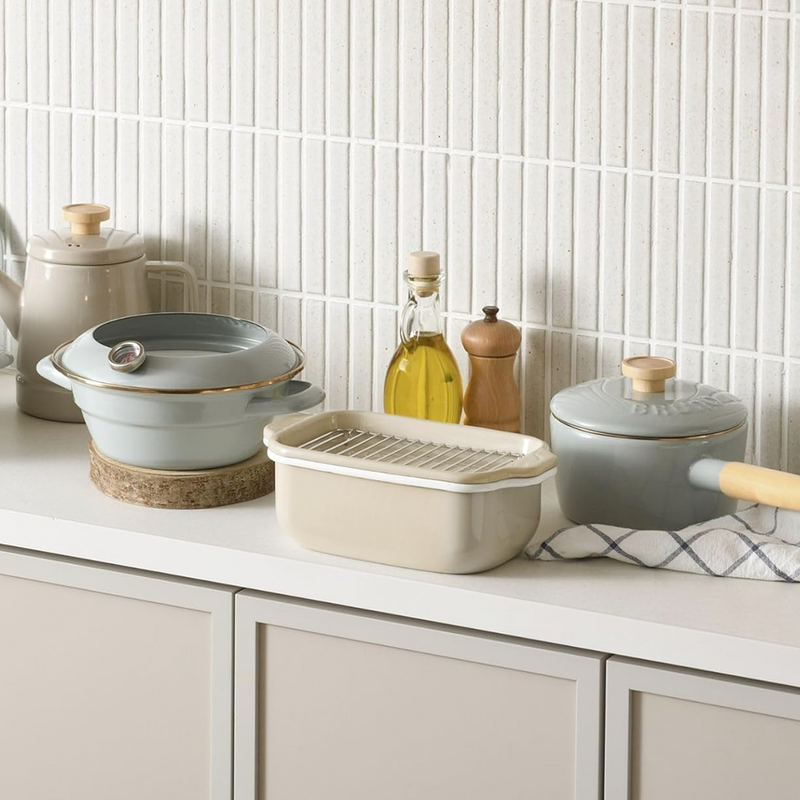 The Fuji enamel deep fryer set styled on a modern kitchen counter with other matching cookware.