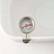 A close-up of the clip-on cooking thermometer, with the dial showing ideal deep-frying temperatures in Celsius.