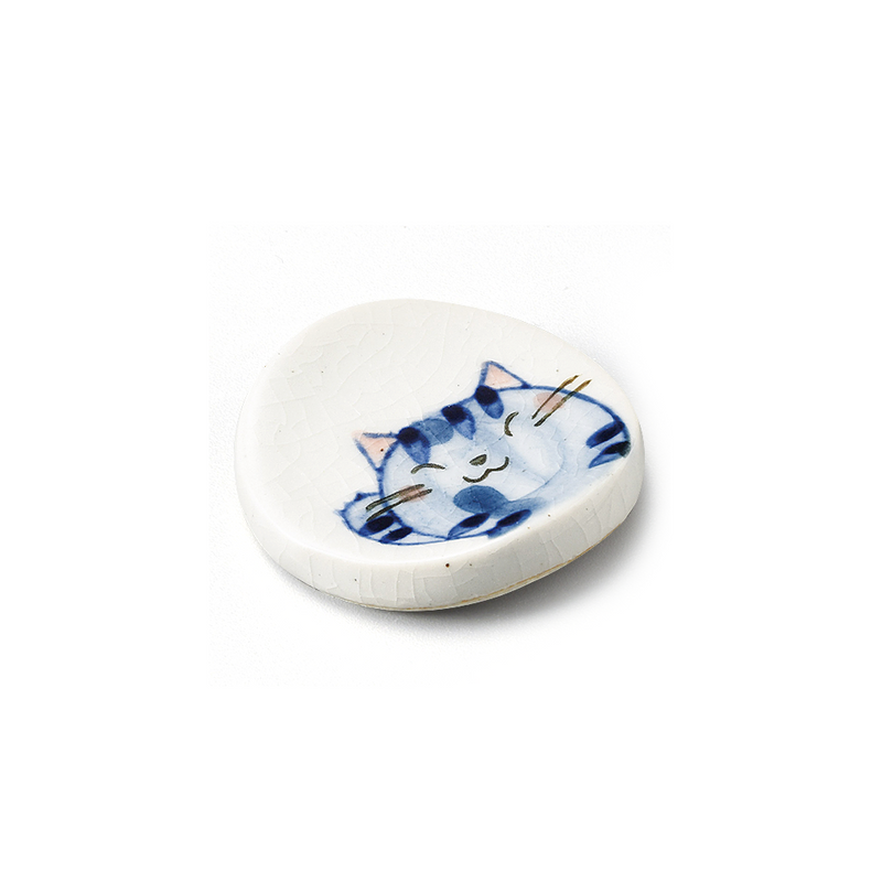 A Japanese porcelain chopstick rest with a crackle glaze, showing a hand-painted illustration of a sleeping blue cat.