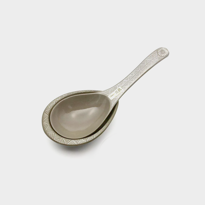 The Ginpo Hana Mishima clay soup ladle resting on its matching clay ladle rest, showing the rustic, earthy texture of the ceramic.