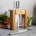 Global Ikasu 5-Piece Knife Block Set displayed on a kitchen countertop with vegetables and a pomegranate, highlighting the bamboo and acrylic block.