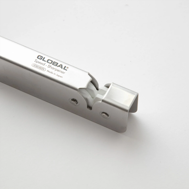  A close-up view of the Global Speed Sharpener, showing the white ceramic sharpening wheels and the "Made in Japan" engraving.