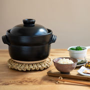 A product image of the Iga-yaki Goemon Donabe Rice Pot, showcasing its semi-matte black glaze, traditional shape, and twisted clay handles.